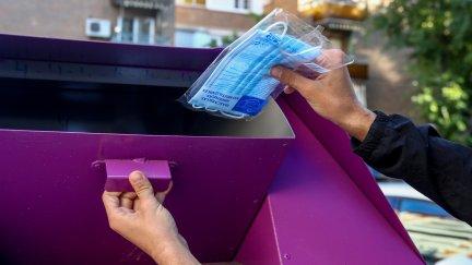 Una persona tira una mascarilla en un contenedor destinado para ello. / Foto: EP