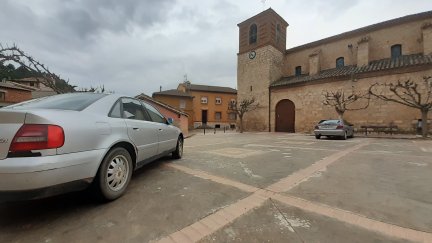 Dos coches, este miércoles, en la plaza de la iglesia de Retascón.