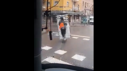 Imagen del vídeo en el que un conductor de patinete transporta un somier.