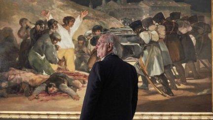 Carlos Saura posa frente a la obra de Francisco de Goya 'Los fusilamientos del 3 de mayo'.
