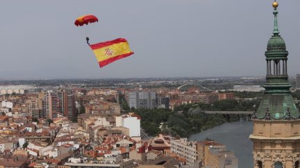 Un paracaidista sobrevuela la plaza del Pilar con una bandera de España. / Foto: Daniel Marcos