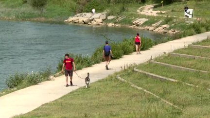 Varias personas pasean por la Ribera del Ebro en Zaragoza.