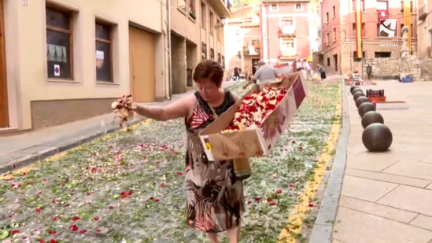 Varios vecinos de Daroca decorando con flores las calles de la localidad.