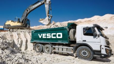 Una máquina retroexcavadora y un camión, en una cantera. / Vesco