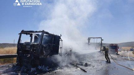 Un bombero apaga el fuego de uno de los camiones. / Diputación de Zaragoza.
