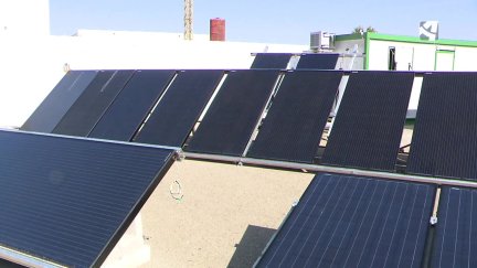 Placas solares en la azotea de una nave.