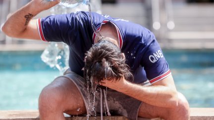 Un joven se tira una botella de agua por encima para combatir el calor. / Europa Press