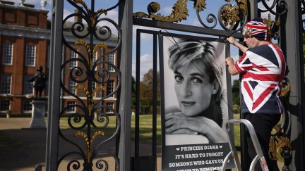John Loughrey, superfan de Diana, cuelga un cartel de la princesa en las puertas del Palacio de Kensington en Londres. EFE / EPA / Tolga Akmen