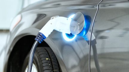 Un coche eléctrico con la manguera de carga. / ANFAC.