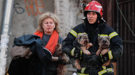 Un rescatista ucraniano ayuda este lunes a una mujer herida y a sus perros tras un bombardeo en el centro de Kiev (Ucrania). (EFE/ Sergey Dolzhenko).