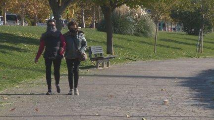 Dos mujeres se protegen del fuerte viento en el Paseo de la Ribera.