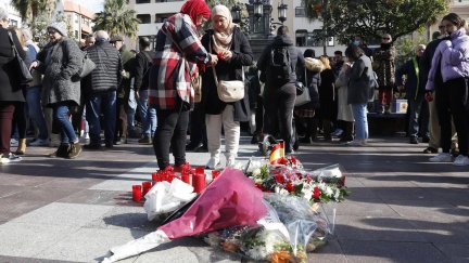 Dos mujeres colocan una vela en el sitio donde asesinaron al sacristán Diego Valencia de la iglesia de la Palma en Algeciras (Cádiz) en la noche del miércoles./ EFE/A.Carrasco Ragel.