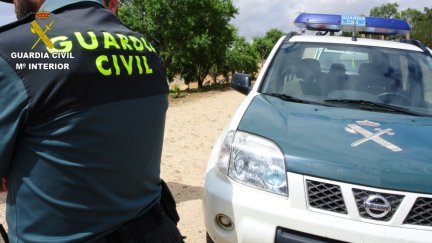 Un agente de la Guardia Civil junto a un vehículo.