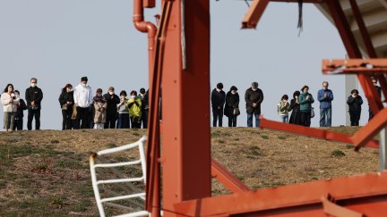 Un grupo de personas recuerda a las víctimas del desastre natural en su 12º aniversario, frente a los restos del Centro de Prevención de Desastres en Minamisanriku, Prefectura de Miyagi, en el norte de Japón. / EFE.