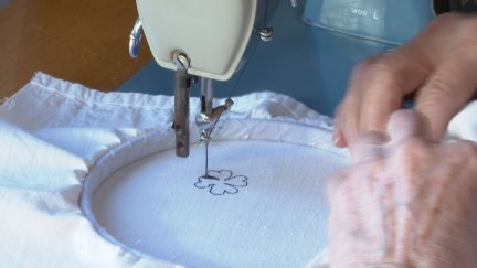 Una bordadora trabaja con su maquina de coser