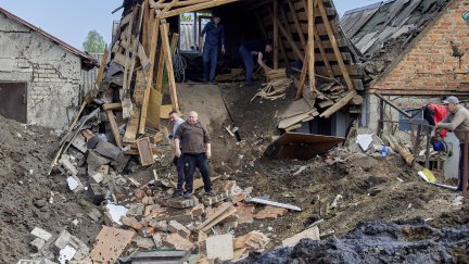 Varios vecinos retiran escombros tras un ataque con cohetes en el asentamiento de Zolochiv, en la zona de Járkov (Ucrania), el 14 de mayo de 2023, en medio de la invasión rusa. / EFE.