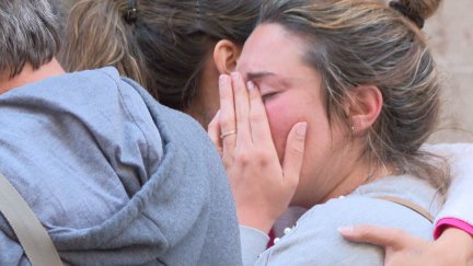 Varios vecinos abrazándose durante la concentración en solidaridad con los afectados