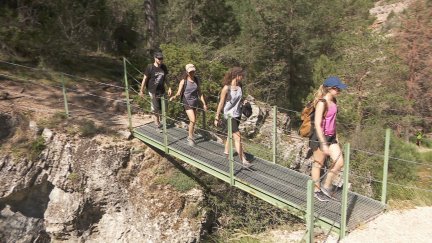 Varias personas recorriendo el cañón del río Blanco, en la localidad turolense de Calomarde.