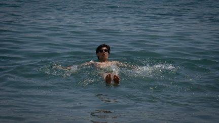 Un hombre se da un baño en la playa de la Barceloneta, en abril de 2023, en Barcelona. / Europa Press