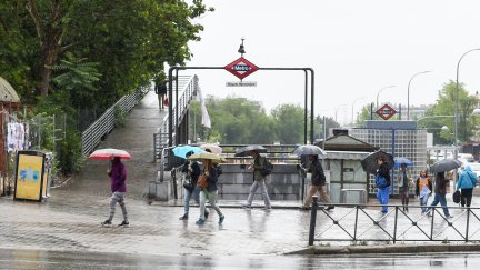 Varias personas pasean bajo la lluvia, a 23 de mayo de 2023, en Madrid. / Europa Press