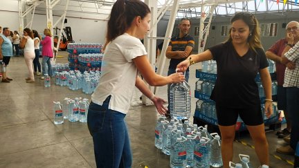 Una vecina recibe una de las garrafas que reparte el Ayuntamiento de Tarazona.