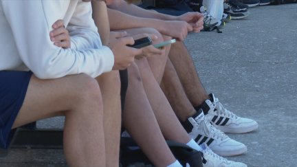Varios menores miran el móvil durante el recreo.