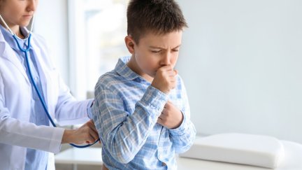 Un profesional sanitario auscultando a un niño. / Canva