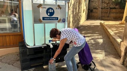Una vecina cogiendo agua de un depósito instalado en Tarazona.