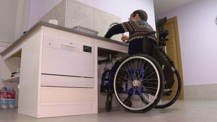 Un discapacitado en silla de ruedas en un domicilio adaptado a su movilidad