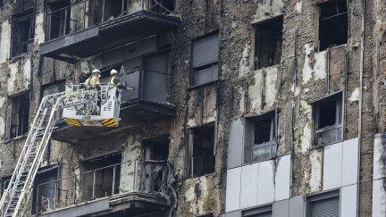 Bomberos en una grúa sanean la fachada quemada. / Europa Press