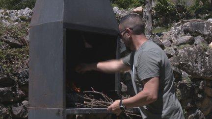 Una personas encendiendo una barbacoa. / Aragón TV