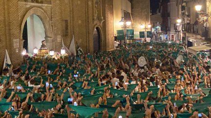 Los peñistas levantan sus pañoletas para despedir a San Lorenzo, cuya peana entra de nuevo a la basílica. / Marimar Viñuales