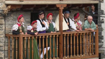 Vecinos de Ansó con en traje tradicional de la localidad en un balcón del municipio. / Aragón Tv