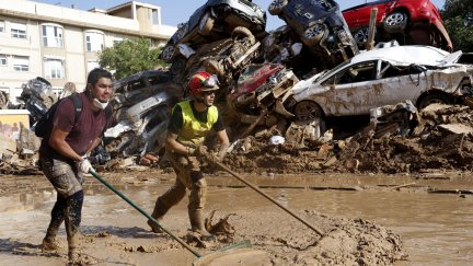 Voluntarios y vecinos despejan una de las calles de Alfafar (Valencia), este miércoles. / EFE /Miguel Ángel Polo