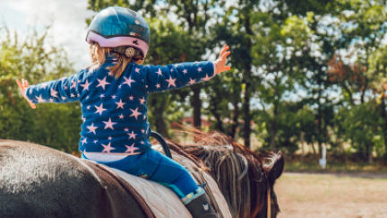 Un menor disfruta sobre un caballo. / Canva