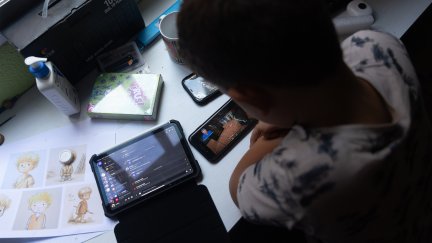Un niño usa el teléfono móvil y una tablet./ Eduardo Parra/ Europa Press