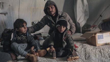 Un hombre y dos niños palestinos en el campamento de Al Zapin, en Deir al Balá, en la Franja de Gaza./ Mohamed Nateel / UNICEF