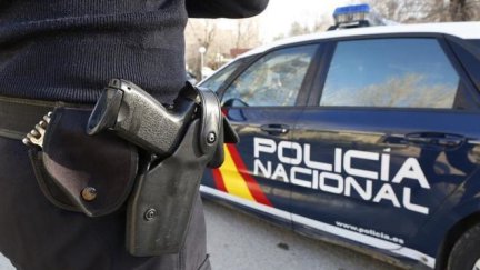 Un coche patrulla y un agente de la Policía Nacional. / Europa Press