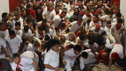 Varios corredores se amontonan en el acceso a la Plaza de Toros durante el segundo encierro de San Fermín. / EFE