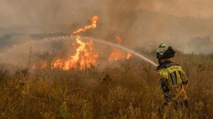 Un bombero trabaja en las labores de extinción del incendio forestal que permanece activo este martes en Monterrei (Ourense). EFE