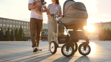 Una pareja paseando con su bebé. / Canva