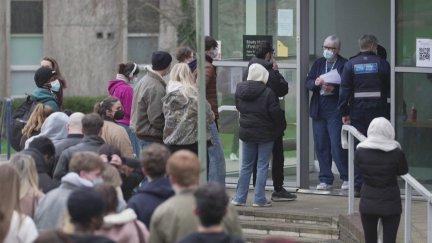 Estudiantes haciendo fila en el campus de la universidad para recibir antibióticos / AFP