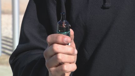 Un joven sostiene en su mano un vapeador. / Aragón TV