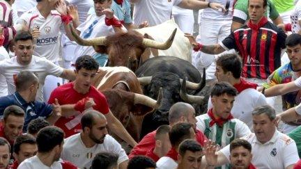 Los toros de la ganadería madrileña de Victoriano del Río, rodeados por los mozos durante el tercer encierro de los Sanfermines 2026, este jueves en Pamplona