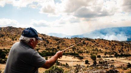 Una persona señala una columna de humo del fuego forestal en Navaluenga (Ávila)