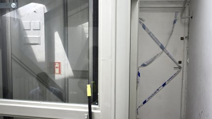 Puerta precintada por la policía en la calle Perines en Santander, donde ha sido asesinada una joven de 27 años.