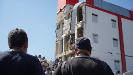 La gente se reúne frente a los escombros de un edificio derrumbado para buscar supervivientes en Cali.