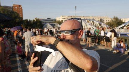 Visitantes equipados con gafas desde el puente de Hierro en Zaragoza.