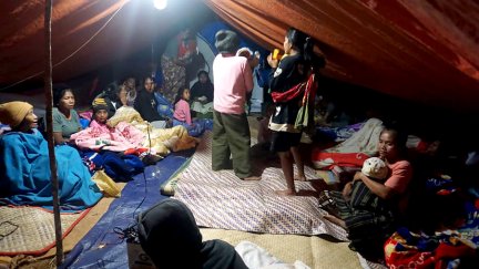 Varias personas descansan en un refugio provisional.