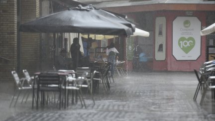(Foto de ARCHIVO)Varias personas se protegen de la lluvia en una terraza de Huesca.